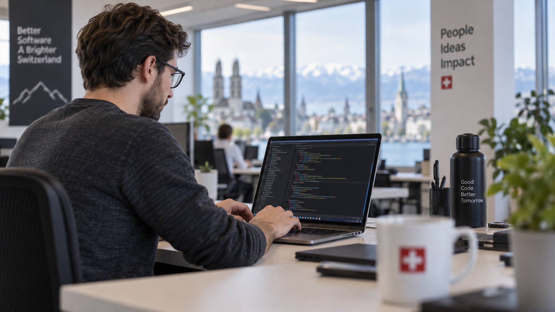 Entwickler arbeitet an einem Laptop in einem modernen Schweizer Büro, im Hintergrund unscharf eine Kaffeetasse.